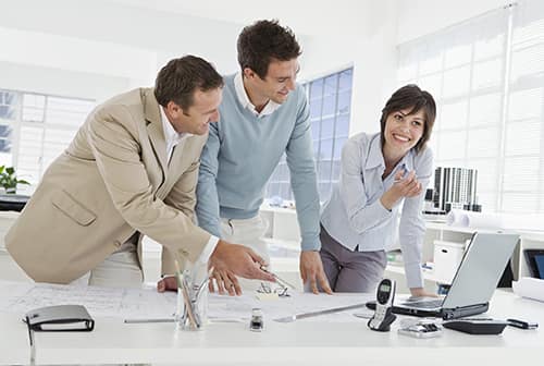 a group of workers at a computer