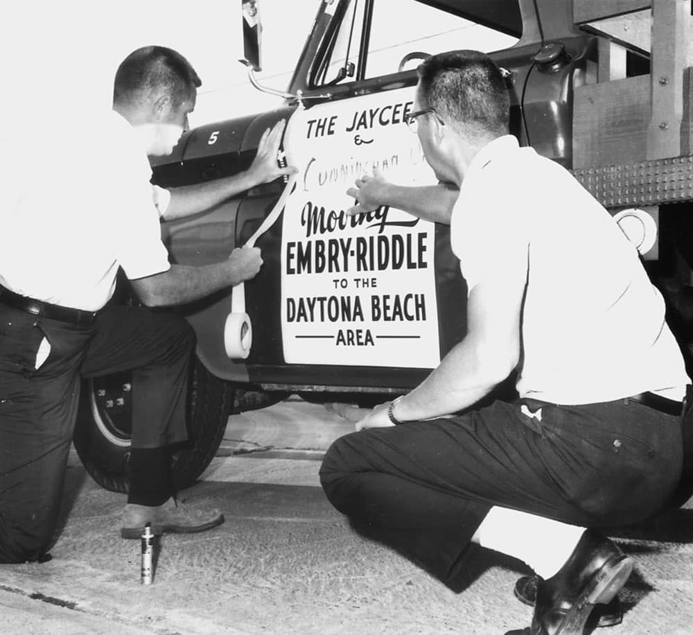 Men add a moving sign to a truck
